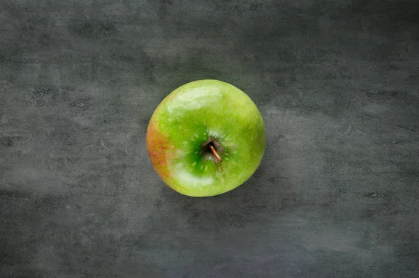 Uma maçã verde no fundo de pedra escura, vista superior . — Fotografia de Stock