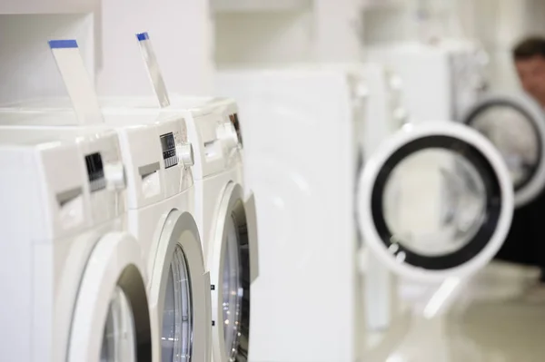 Waschmaschinen im Gerätehaus und defokussierter Käufer — Stockfoto