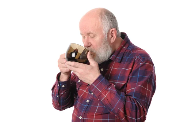 Uomo anziano che beve da tazza, isolato su bianco — Foto Stock