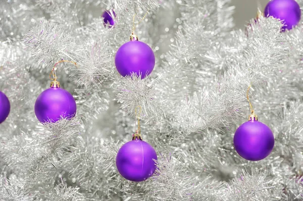 Trendige farbige ultraviolette Christbaumkugeln auf einem silbernen künstlichen Weihnachtsbaum — Stockfoto