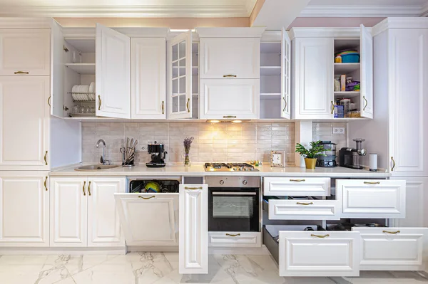 Luxury modern white kitchen interior with open doors and drawers — Stock Photo, Image