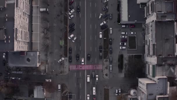 Akşamüstü, yoğun şehir trafiğinin yoğun olduğu tepeden aşağıya doğru insansız hava aracı uçuşu. — Stok video