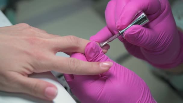 Close-up de esteticista manicure cobrindo clientes unhas com brilho esmalte de unhas — Vídeo de Stock
