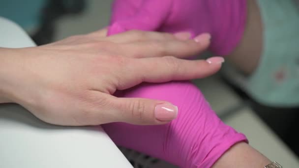 Крупный план маникюра косметолог салфетки клиентов полированные ногти с тканями — стоковое видео