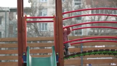 Küçük kız, çocuk parkında kayıyor.