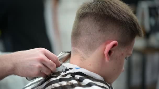 Joven hombre corte de pelo en la barbería. Primer plano del cabello de recorte maestro con clipper — Vídeos de Stock