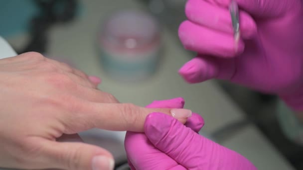 Manicura esteticista que cubre las uñas de los clientes con gel esmalte — Vídeo de stock