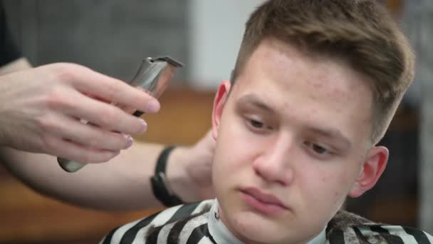 Corte de cabelo jovem homem na Barbearia. Close-up de cabelo de corte mestre com clipper — Vídeo de Stock