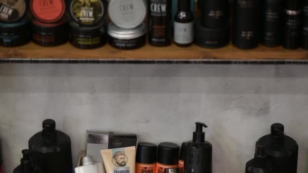 Detalhe da barbearia sortidas fornece produtos em prateleiras vitrine — Vídeo de Stock