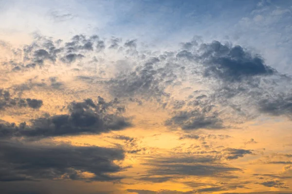 Pôr do sol azul, amarelo e laranja com nuvens — Fotografia de Stock