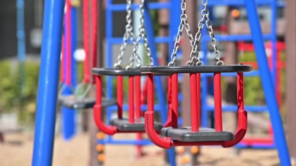 Zeitlupe von Schaukeln auf leerem Kinderspielplatz im Wohngebiet von Chisinau, Moldawien während der Covid-19-Virusbedrohung — Stockvideo