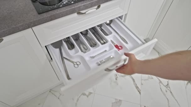 Мужская рука берет ложки из кухонного ящика — стоковое видео