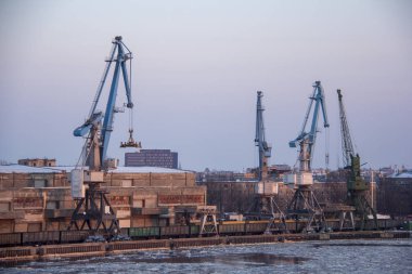 Nakliye konteyner yük ve gaz petrol tankları rıhtımda. ithalat ihracat ve lojistik iş. Kargo gemisi, limana demirledi. Kargo Vinçler kış akşam bağlantı noktası Riga, Letonya.