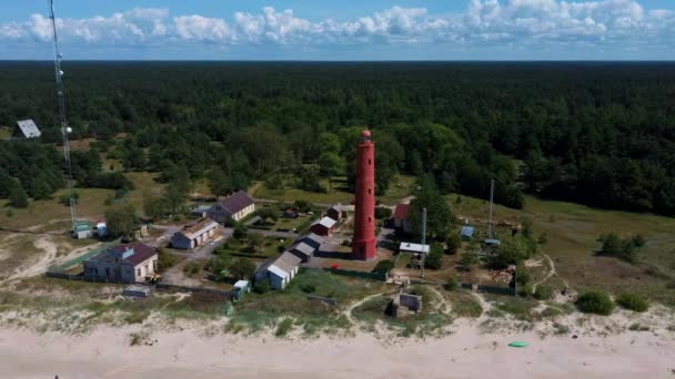 空中ドローンショットAkmenragsバルト海のラトビア沿岸の灯台は パヴィオスタのリゾートタウンの南に位置しています 晴れた夏の日 現在の塔は1921年に建てられた — ストック動画