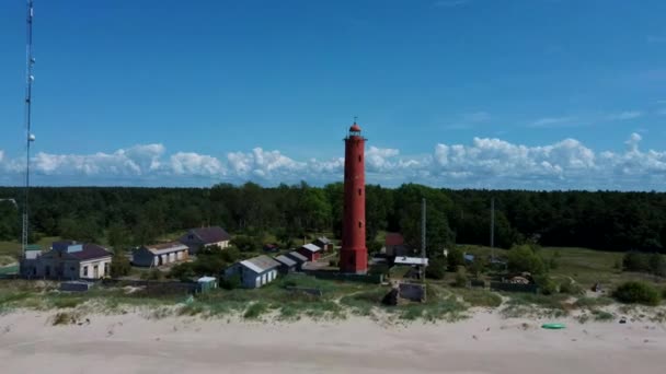 空中ドローンショットAkmenragsバルト海のラトビア沿岸の灯台は パヴィオスタのリゾートタウンの南に位置しています 晴れた夏の日 現在の塔は1921年に建てられた — ストック動画