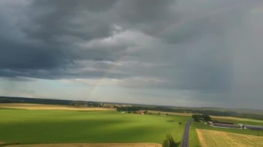 Buğday tarlasının üstündeki gökkuşağı. Yağmur Sonrası Olgun Ekin Tarlası ve Kırsal Arazide Renkli Gökkuşağı Uçuşu. Hava Dron Atışı.
