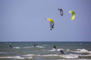 11 Ağustos 2019, Liepaja, Letonya: Baltık Denizi Güneşli Yaz Gününün Kiteboardcuları ve Kitesurfers. Uçurtma sörfü ve uçurtma tahtasına atlama 