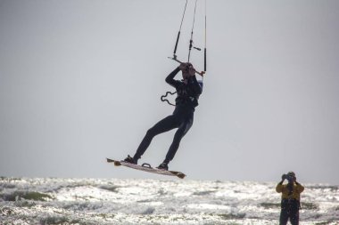 11 Ağustos 2019, Liepaja, Letonya: Baltık Denizi Güneşli Yaz Gününün Kiteboardcuları ve Kitesurfers. Uçurtma sörfü ve uçurtma tahtasına atlama 