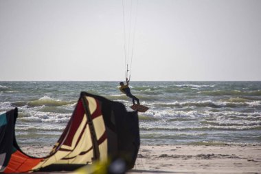 11 Ağustos 2019, Liepaja, Letonya: Baltık Denizi Güneşli Yaz Gününün Kiteboardcuları ve Kitesurfers. Uçurtma sörfü ve uçurtma tahtasına atlama 