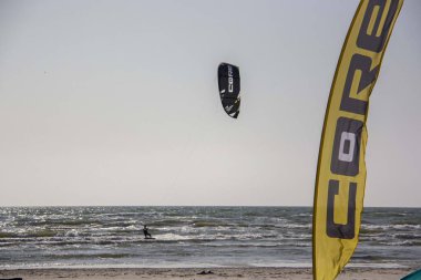 11 Ağustos 2019, Liepaja, Letonya: Baltık Denizi Güneşli Yaz Gününün Kiteboardcuları ve Kitesurfers. Uçurtma sörfü ve uçurtma tahtasına atlama 