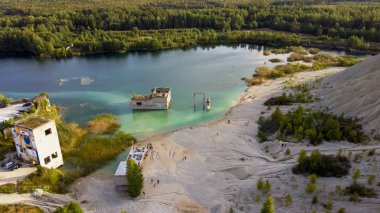 Rummu Estonya Avrupa 'da bir Gölet ve Terk Edilmiş Cezaevi ile Kum Tepeleri. Eski Cezaevi 'ni su bastı. Terk Edilmiş Madenlerdeki Dağ Sovyet Zaman Hapishanesi Mimarisinin Batık Harabeleri.