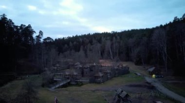 Tervete Doğa Parkı 'ndaki Tahta Şato, Orman ve Nehir Tervete' nin hava görüntüsü. Letonya 'da turistlerin ilgisini çekiyor. Kış Akşamı Gündoğumu. Ormana park et, Cücelerin Tahta Heykelleriyle, Canavarlarla
