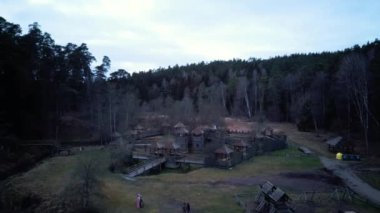 Tervete Doğa Parkı 'ndaki Tahta Şato, Orman ve Nehir Tervete' nin hava görüntüsü. Letonya 'da turistlerin ilgisini çekiyor. Kış Akşamı Gündoğumu. Ormana park et, Cücelerin Tahta Heykelleriyle, Canavarlarla
