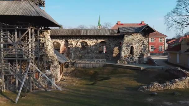 ラトビア リンバジ中世の城遺跡 13世紀の城の空中ビュー 新しい作成高展望台と石の遺跡 背景にある教会と都市 — ストック動画