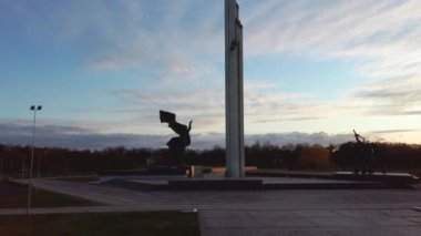 Riga, Letonya 'daki Zafer Parkı' nın Hava Günbatımı Manzarası. Zafer anıtı. Kamera Yandan Hareket Ediyor.