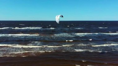Kiteboardcuların ve Kitesurfers 'ın Baltık Denizi' ndeki Letonya Hava Aracı 4k 'de çekilmiş görüntüleri. Güneşli bir bahar günü. Uçurtma Tahtasında Uçan Adam