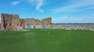Ludza Ortaçağ Kalesi 'nin Büyük Ludza Gölü ile Küçük Ludza Gölü arasındaki bir tepedeki hava manzarası. Letonya 'daki Antik Kale' nin kalıntıları. Güneşli Bahar Günü