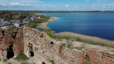 Ludza Ortaçağ Kalesi 'nin Büyük Ludza Gölü ile Küçük Ludza Gölü arasındaki bir tepedeki hava manzarası. Letonya 'daki Antik Kale' nin kalıntıları. Güneşli Bahar Günü
