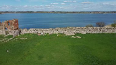 Ludza Ortaçağ Kalesi 'nin Büyük Ludza Gölü ile Küçük Ludza Gölü arasındaki bir tepedeki hava manzarası. Letonya 'daki Antik Kale' nin kalıntıları. Güneşli Bahar Günü