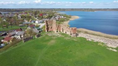Ludza Ortaçağ Kalesi 'nin Büyük Ludza Gölü ile Küçük Ludza Gölü arasındaki bir tepedeki hava manzarası. Letonya 'daki Antik Kale' nin kalıntıları. Güneşli Bahar Günü