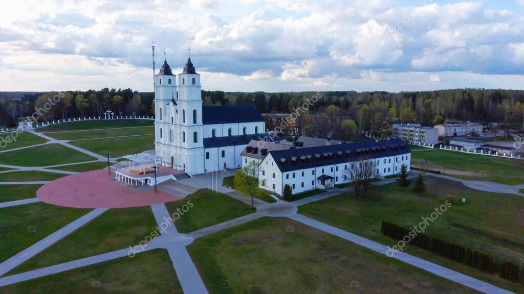 Aerial View Majestic Aglona Cathedral in Latvia. White Chatolic Church Basilica. Sunny Spring Day Blue Sky and White Clouds. One of the Most Important Catholic Spiritual Centers in Latvia