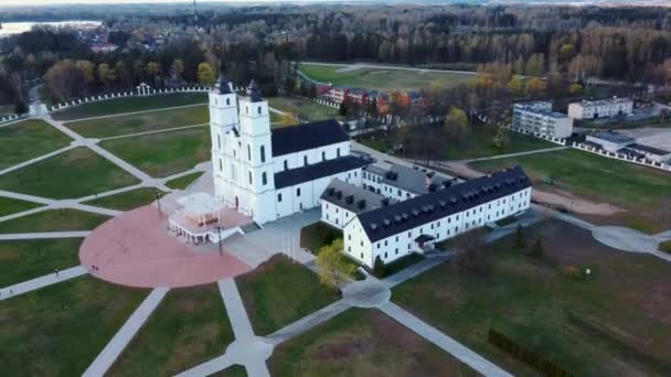 空中からの眺めラトビアの雄大なアゴナ大聖堂 ホワイト カトリック教会 晴れ春の日青空と白い雲 ラトビアで最も重要なカトリックの霊的センターの一つ — ストック動画
