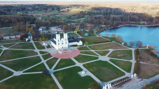 空中からの眺めラトビアの雄大なアゴナ大聖堂 ホワイト カトリック教会 晴れ春の日青空と白い雲 ラトビアで最も重要なカトリックの霊的センターの一つ — ストック動画