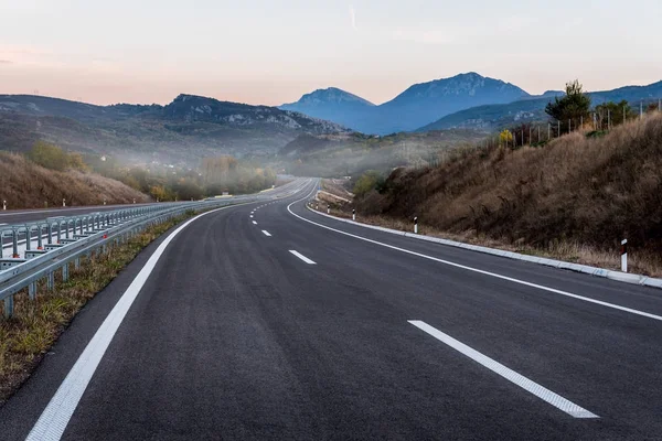 日落时有标记的空公路 — 图库照片