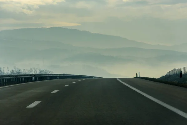 Nevoeiro Sobre Sinuosa Rodovia Que Conduz Montanhas Através Paisagem Rural — Fotografia de Stock