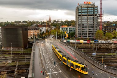 Basel, İsviçre - 03 Kasım 2019: Demiryolu üzerinde tramvay ve arabalarla şehir trafiğinin manzarası