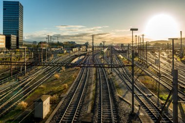 Tren rayları ve trenleriyle gündoğumunda modern Avrupa tren istasyonu