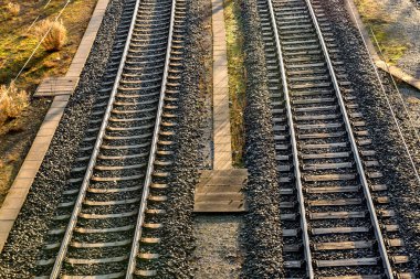 Tren rayları ve trenleriyle gündoğumunda modern Avrupa tren istasyonu