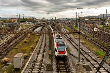 Gündoğumunda tren rayları ve trenleri olan bir Avrupa tren istasyonunda modern banliyö treni
