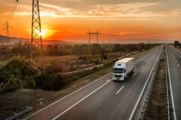 Jeden Nákladní Automobil Venkovské Dálnici Pod Úžasnou Oranžovou Oblohou Západ — Stock fotografie