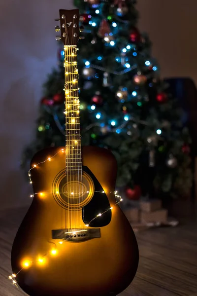 Gitara Lampkami Świątecznymi Miękkim Ogniskowane Choinki Tle — Zdjęcie stockowe