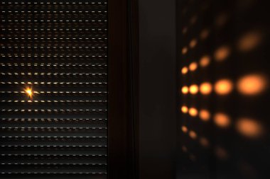 Kepenkler - sabahları güneş ışığıyla kör olur. Jaluzili koyu tahta pencere. Pencere perdeleri olan oturma odasının iç tasarımı. Yumuşak odak arkaplanı soyut 