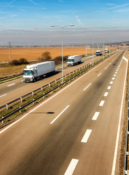 Konvoj Bílých Nákladních Automobilů Řadě Venkovské Silnici Pod Krásnou Modrou — Stock fotografie