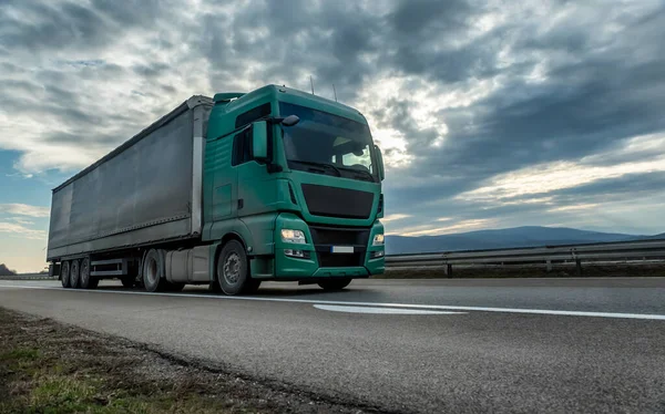 Grüner Sattelschlepper Auf Einer Autobahn Mit Dramatischem Sonnenuntergang Hintergrund Transportmittel — Stockfoto