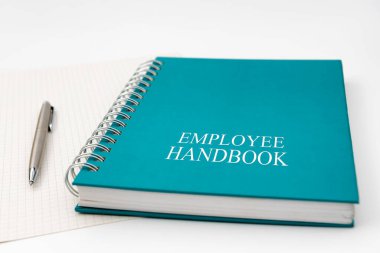 Employee Handbook or manual with a pen and paper on a white table in an office - personnel management policy, explains business goals, results, defines personnel practices clipart