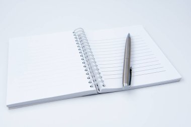 Defteri beyaz ofis masasında kalemle aç